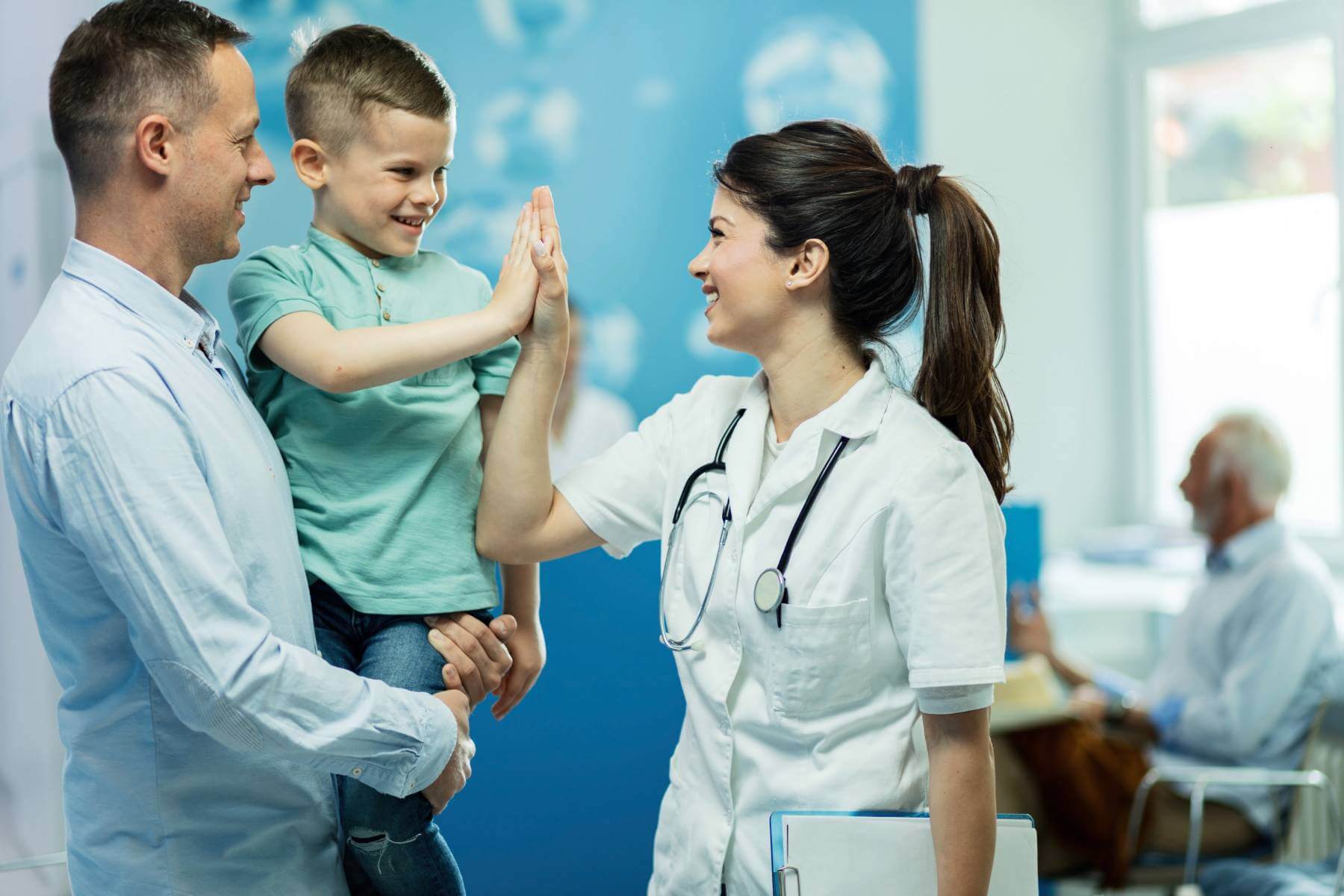 A child high-fives his doctor